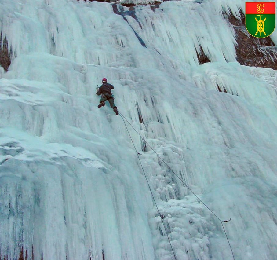 Especialista en Montaña realizando escalada en hielo en entorno invernal