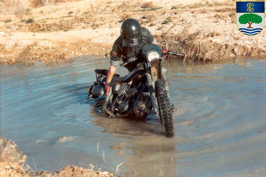 Especialista SEPRONA cruzando terreno inundado en motocicleta