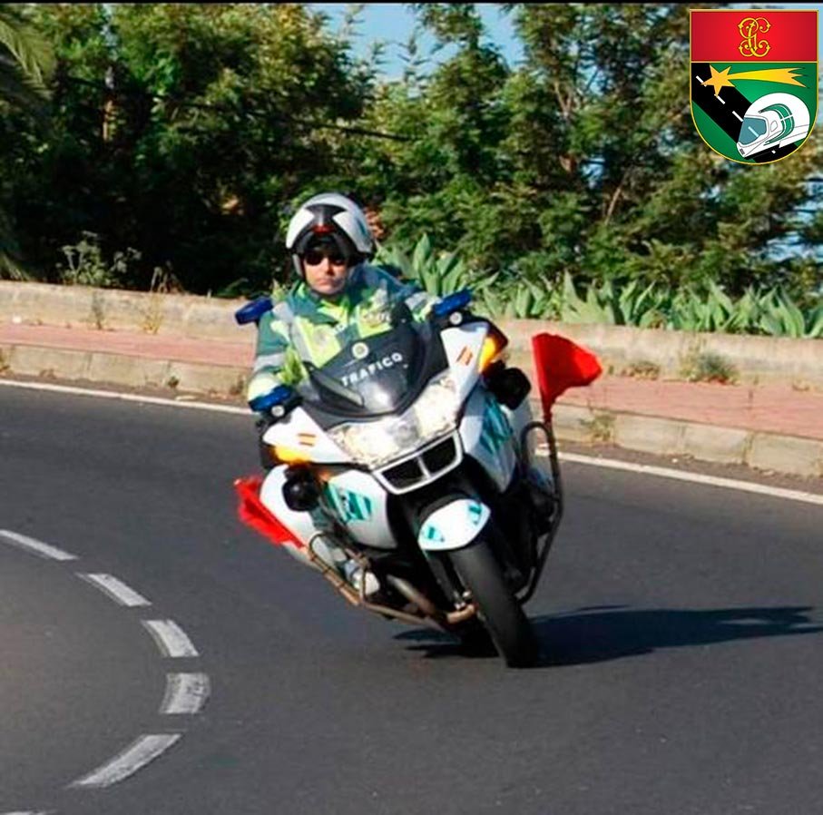 Motorista de la Guardia Civil señalizando con bandera roja en carretera