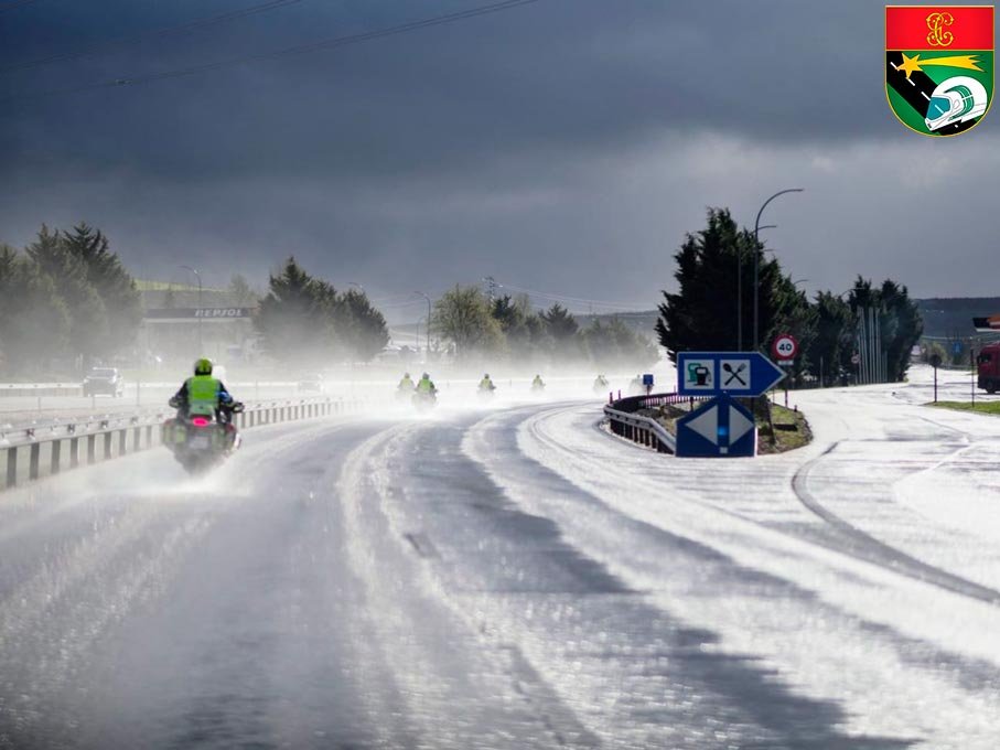 Motoristas de la Guardia Civil prestando servicio bajo lluvia en carretera