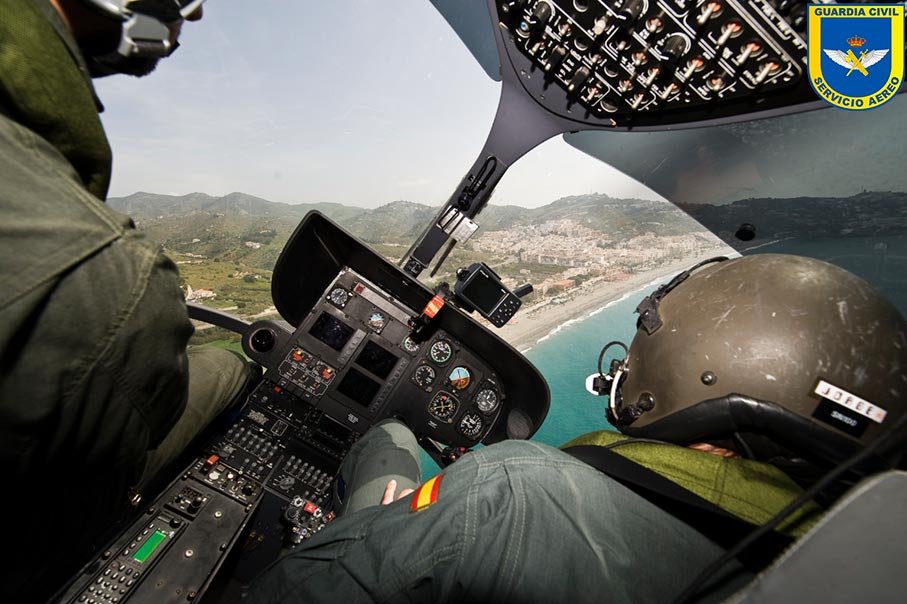 Pilotos de helicóptero de la Guardia Civil durante vuelo operativo sobre zona costera