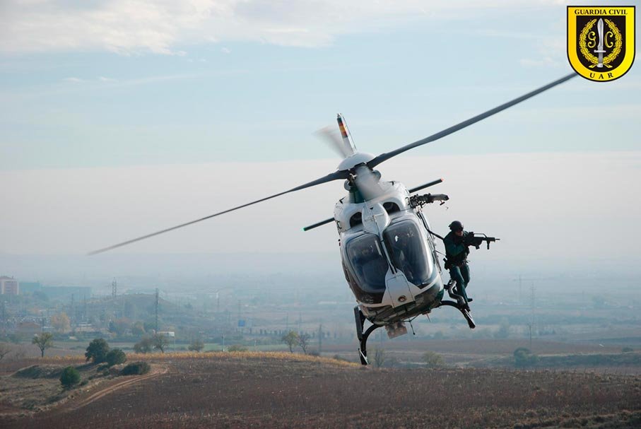 Agente de la UAR Guardia Civil descendiendo desde helicóptero durante operación aérea.