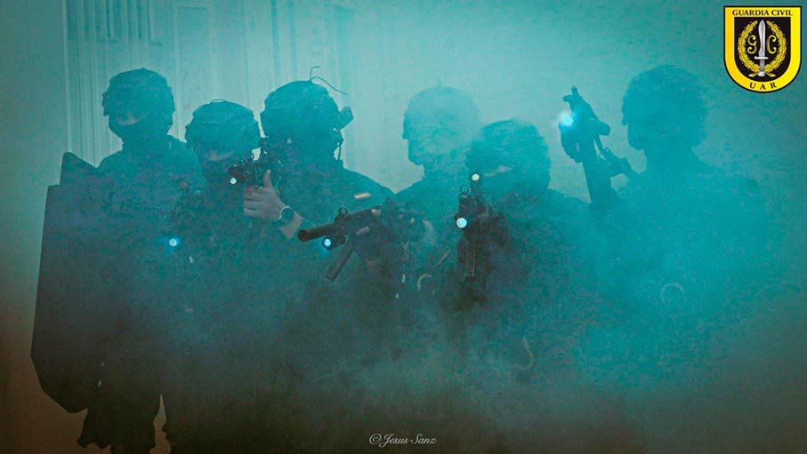 Equipo de la UAR Guardia Civil avanzando en formación durante intervención en entorno con humo.