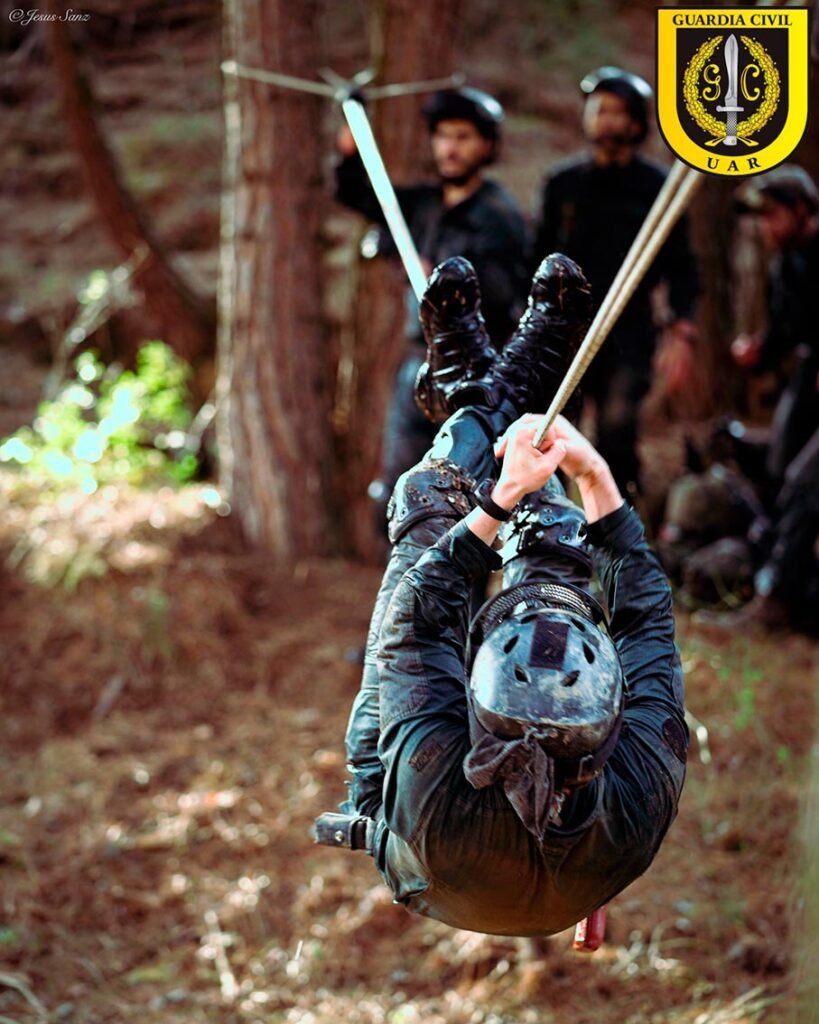 Operador de la UAR Guardia Civil realizando maniobra en tirolina durante entrenamiento en bosque.