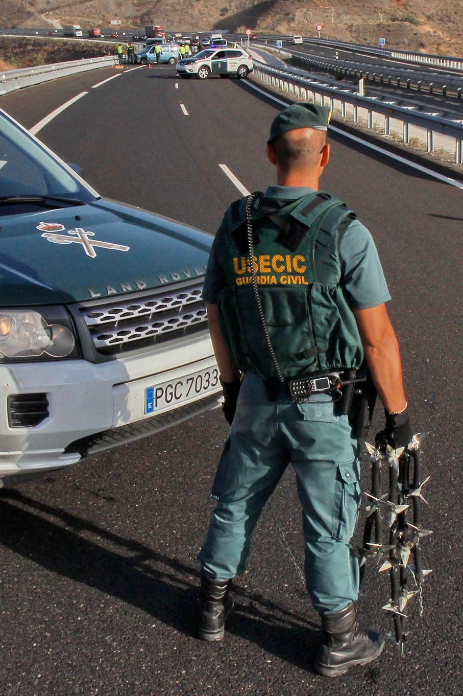 Agente de la USECIC junto a vehículo oficial durante control en carretera