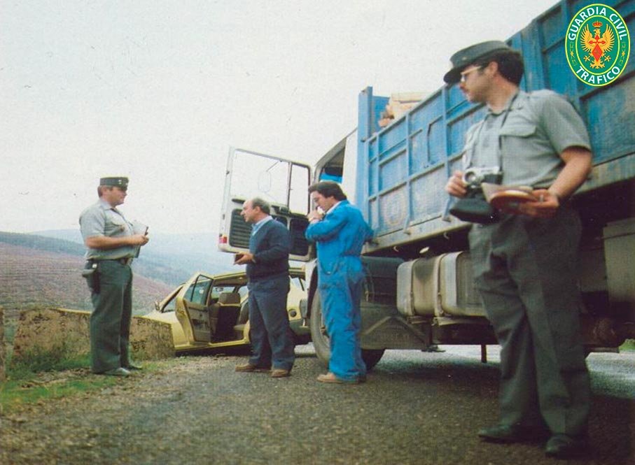 Guardias civiles de Tráfico tomando datos junto a un camión y un turismo accidentados en los años 80