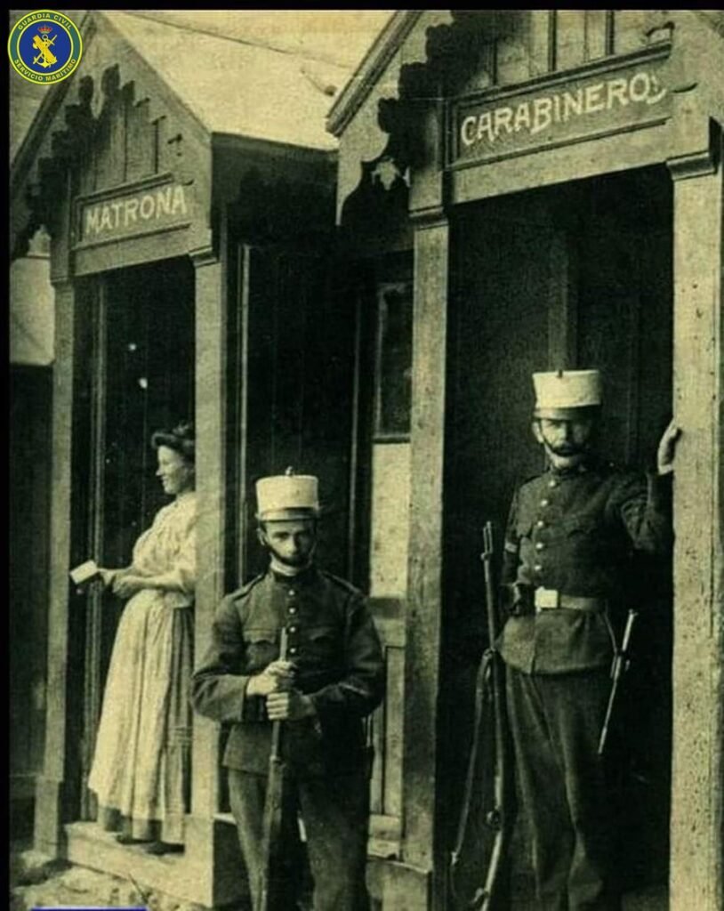 Dos carabineros armados y una matrona en sus garitas de servicio, en una fotografía antigua en sepia