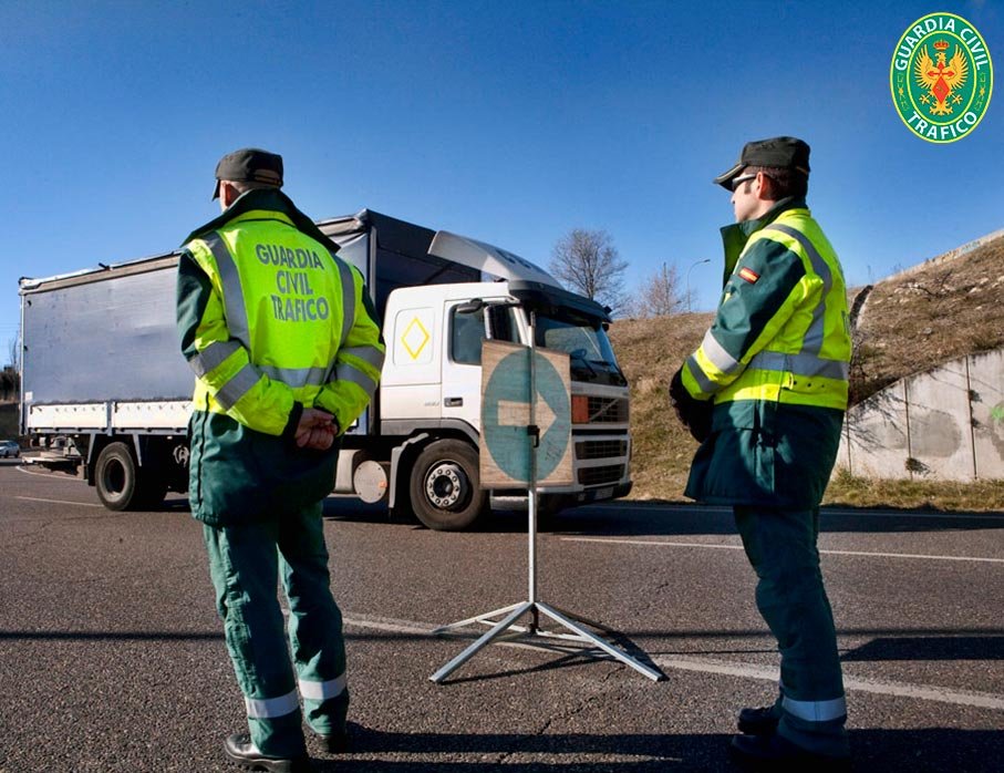 Dos agentes de la Guardia Civil de Tráfico indican a un camión que se desvíe hacia un control