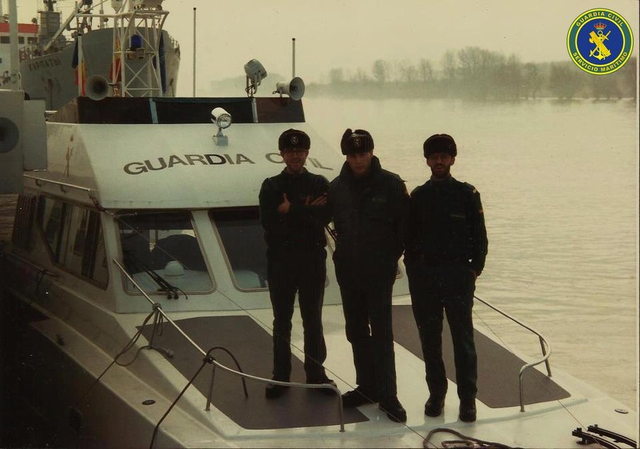 Tres guardias civiles con ropa de invierno en la cubierta de una embarcación del Servicio Marítimo durante el Embargo del Danubio