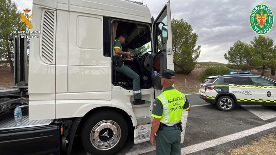 Agentes de la Guardia Civil de Tráfico inspeccionando la cabina de un camión durante un control de transporte