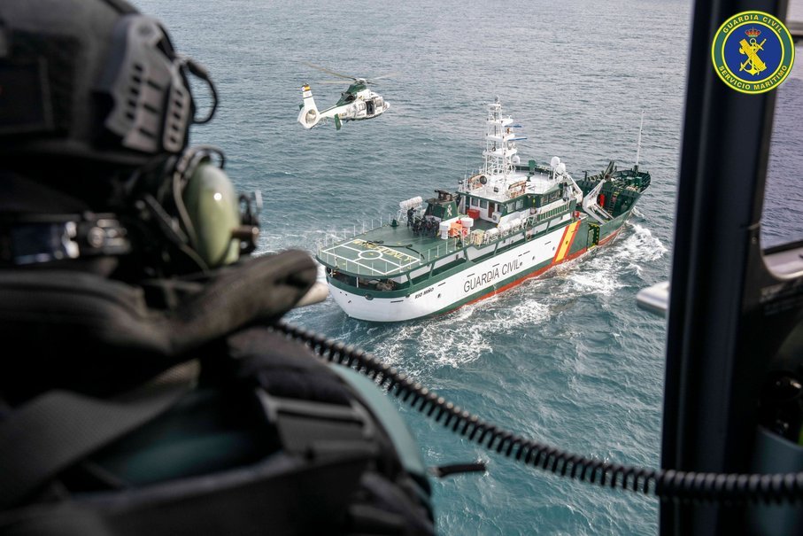 Buque del Servicio Marítimo y helicóptero de la Guardia Civil durante un operativo conjunto, vistos desde otro helicóptero