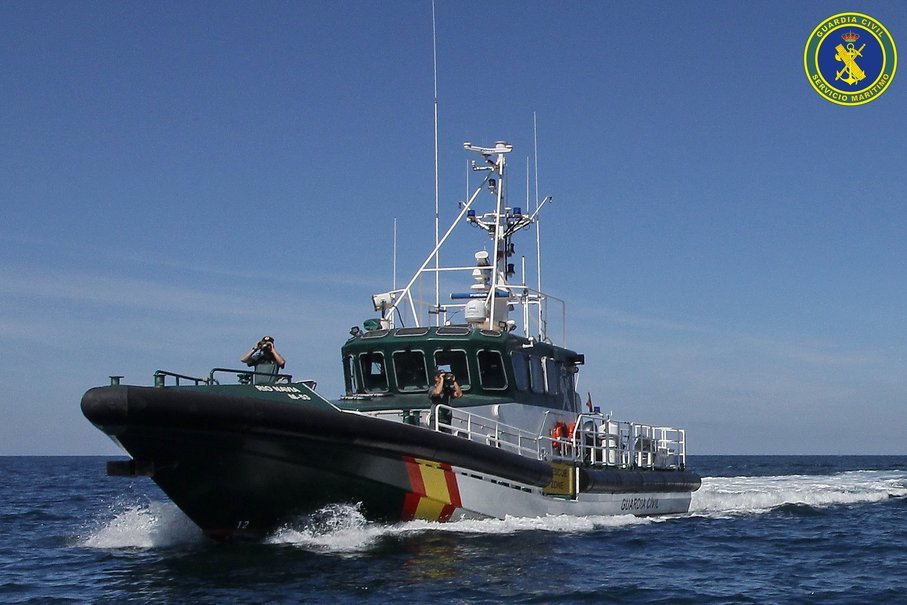 Agentes de la Guardia Civil vigilando con prismáticos desde la patrullera Río Navia